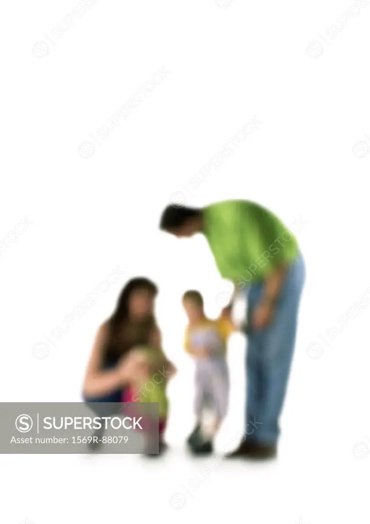 Silhouette of parents speaking to two children, on white background, defocused