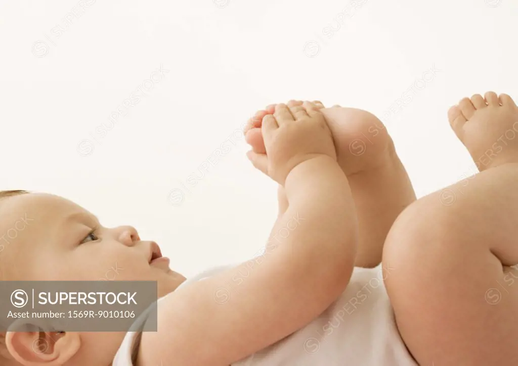 Baby lying down, holding foot