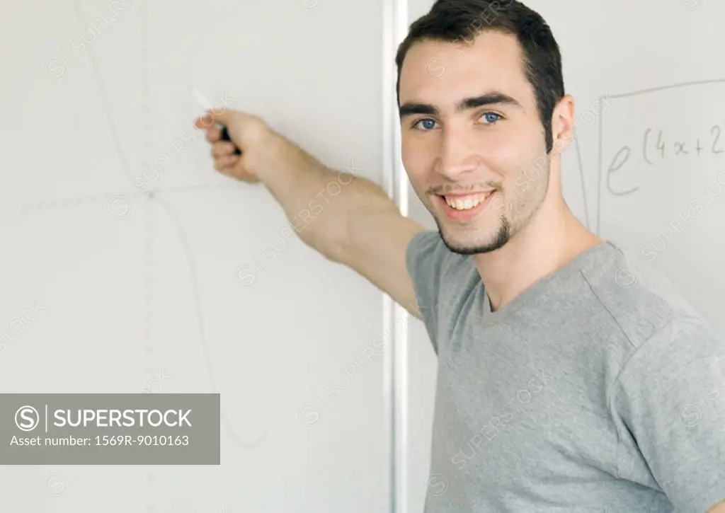 Young man writing on whiteboard