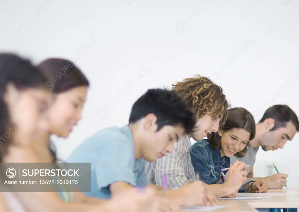 Students sitting side by side in class, doing class work