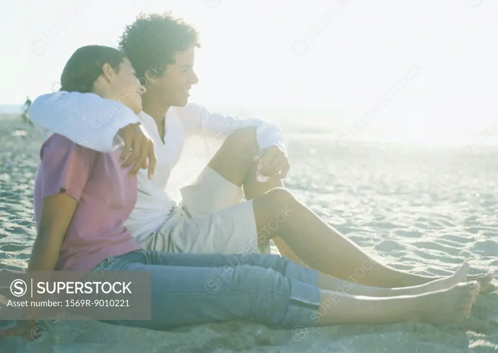 Teenage couple sitting on beach