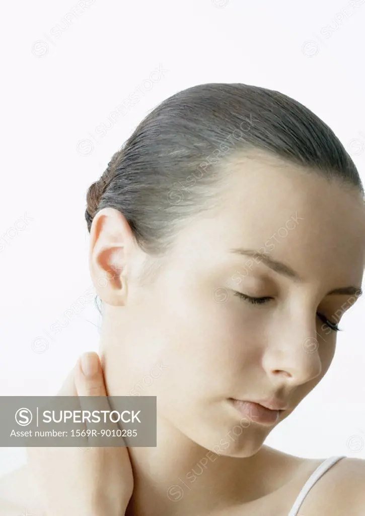 Woman with hand on neck and eyes closed