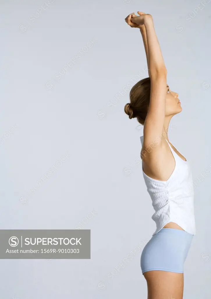 Young woman stretching arms over head
