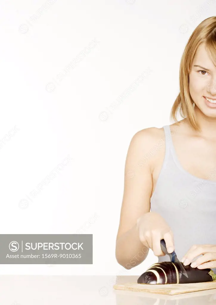 Young woman slicing eggplant