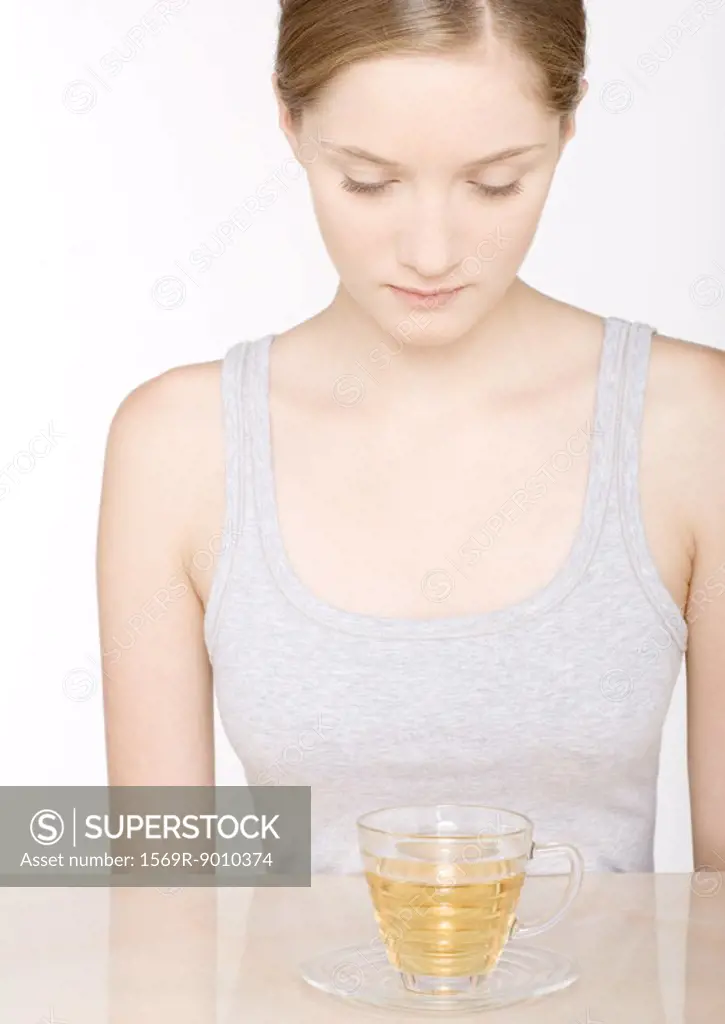 Young woman looking down at herbal tea