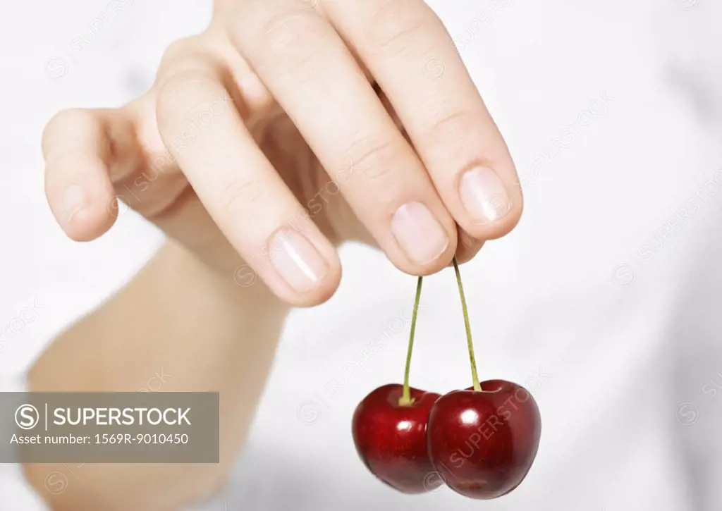 Hand holding cherries