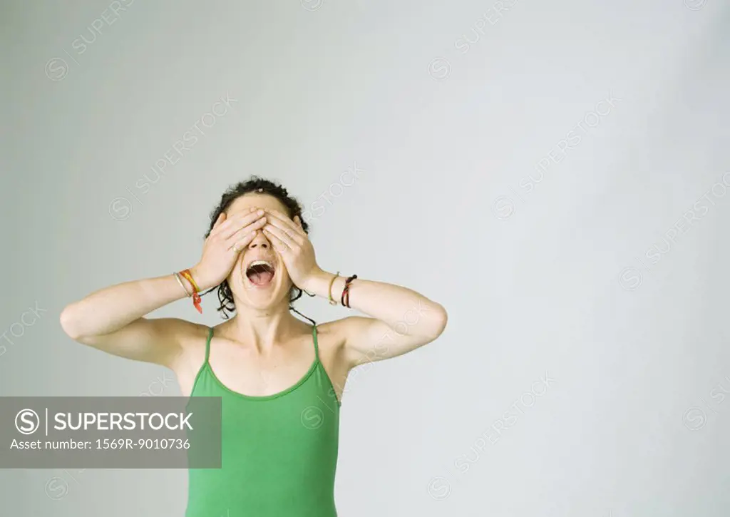 Young woman screaming and covering eyes