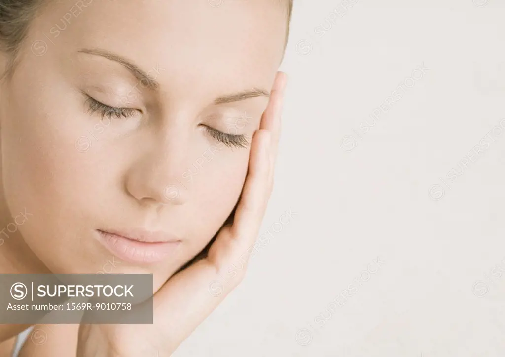 Young woman with eyes closed resting head on hand