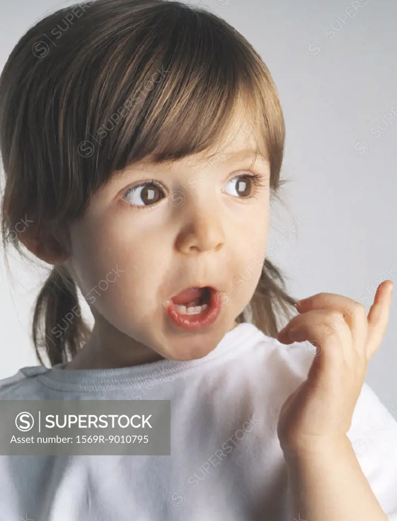 Little girl making face and pointing, portrait