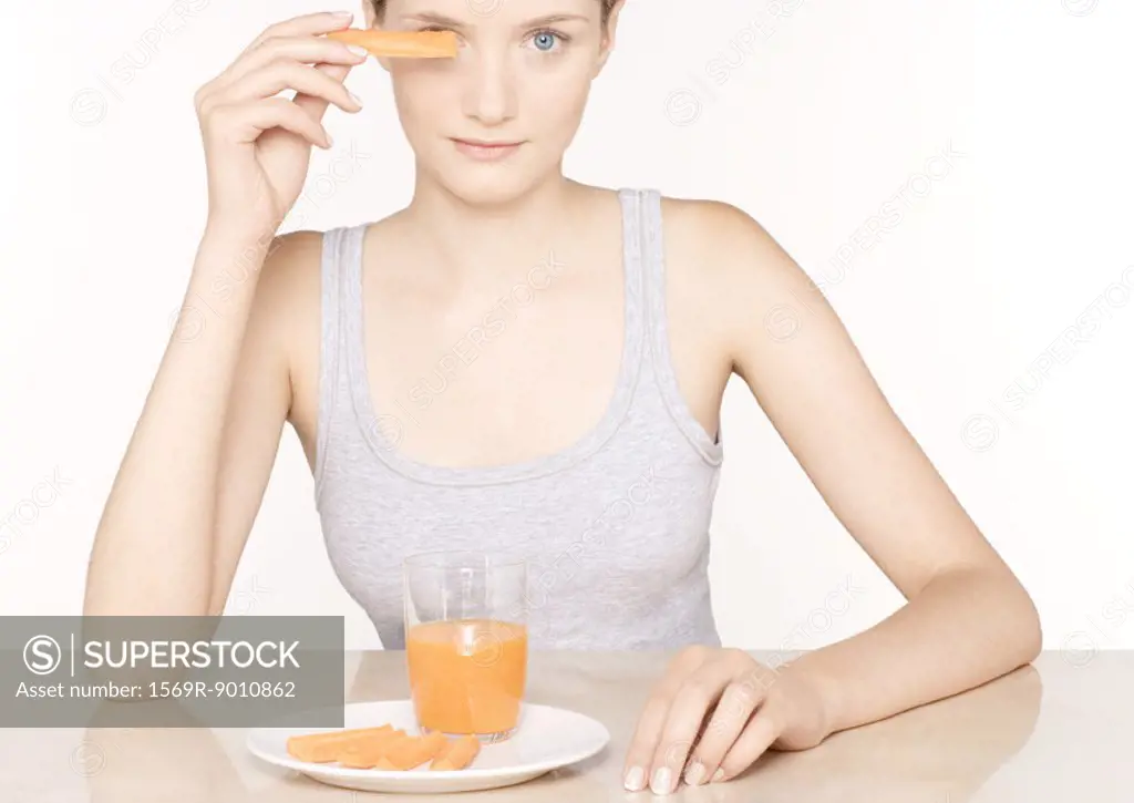 Woman with carrot juice and slices of carrots