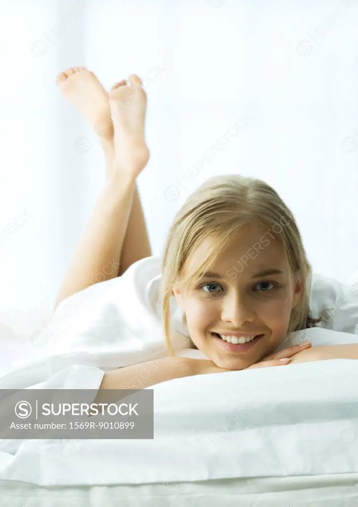 Young woman lying on stomach with legs up