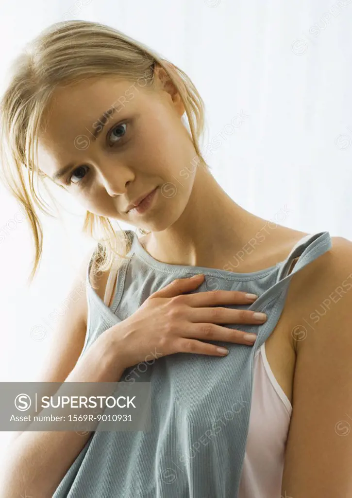 Young woman holding up tank top