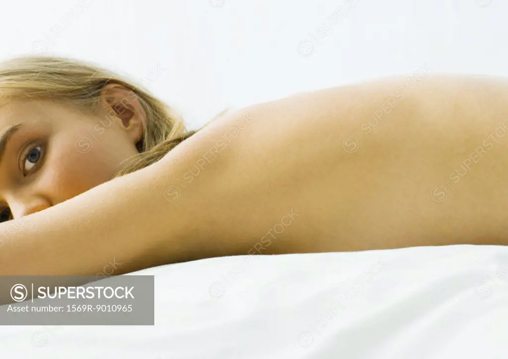 Young woman lying on bed nude