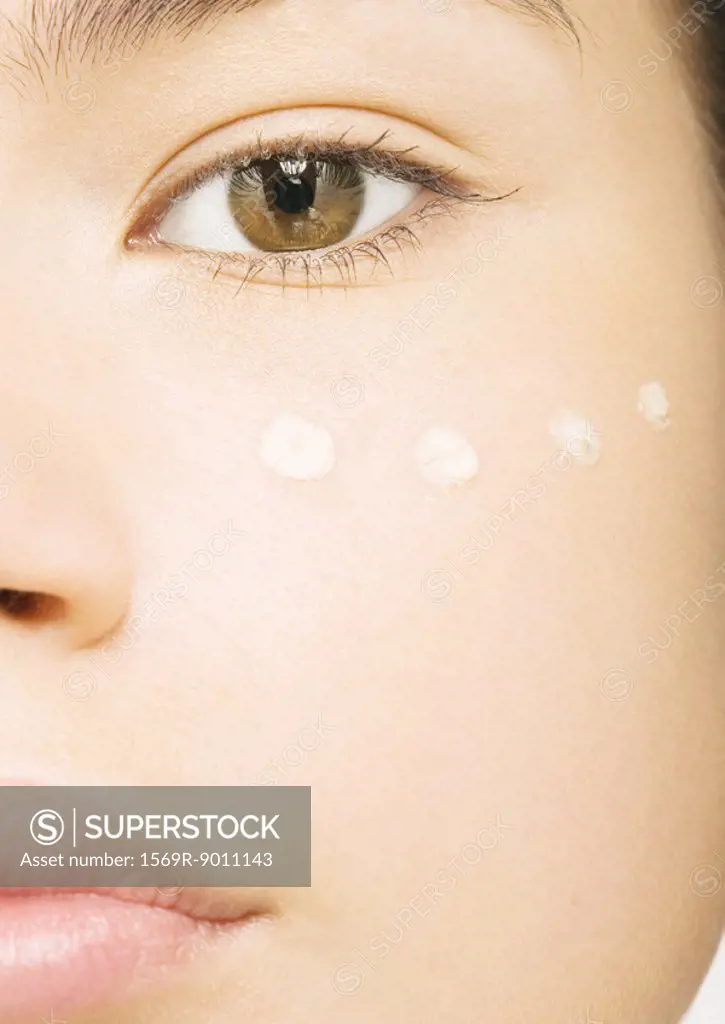 Woman´s face with concealer under eye, close-up