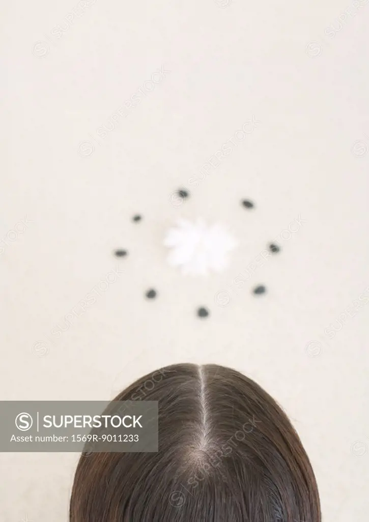 Back of woman´s head and flower inside circle