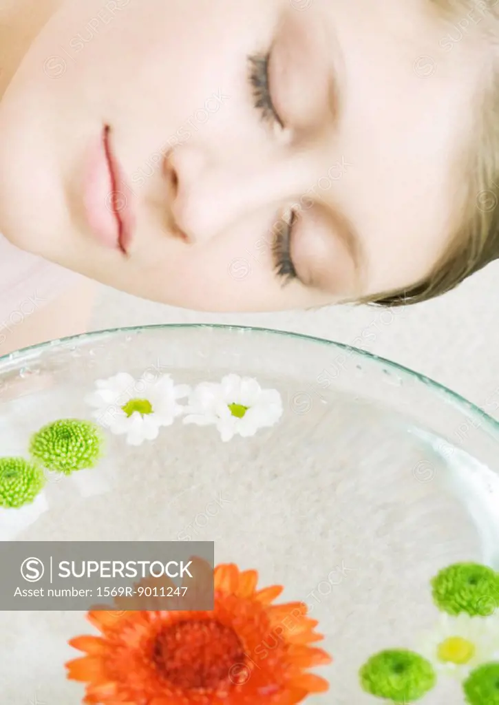 Woman´s face and bowl of flowers floating in water