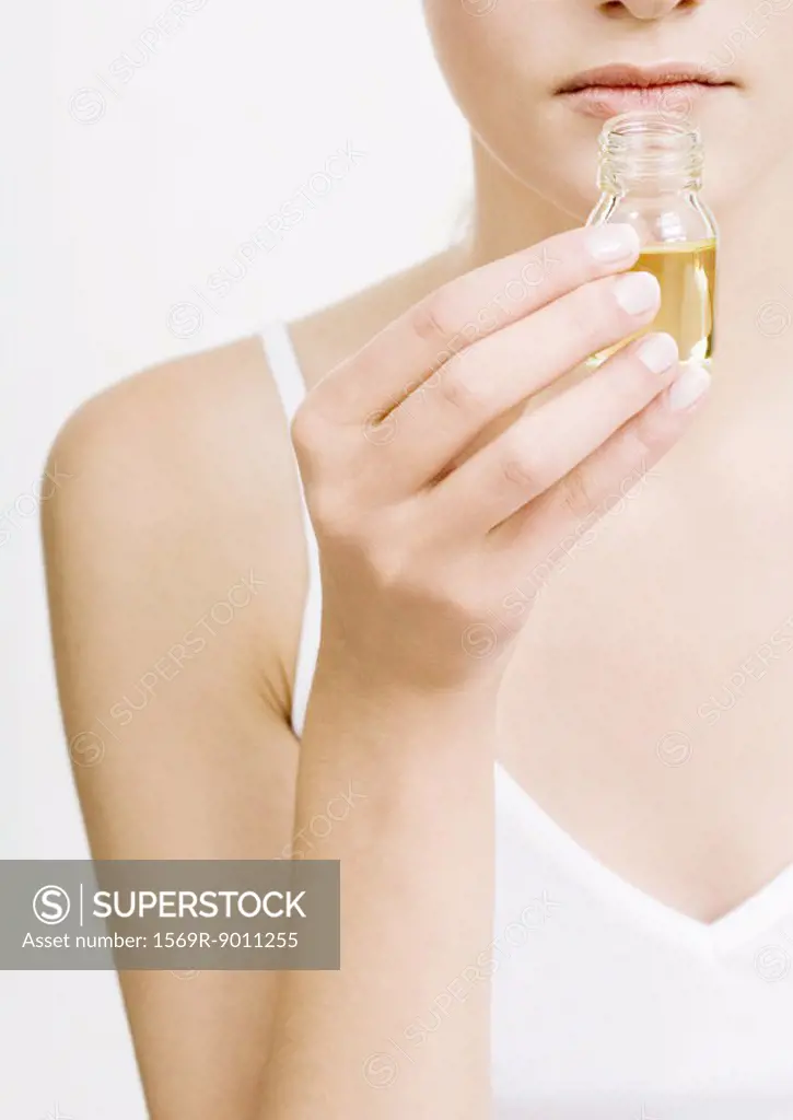 Woman smelling bottle of essential oil