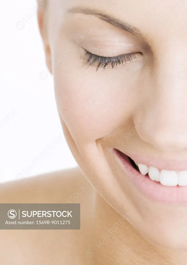 Woman with eyes closed smiling, close-up