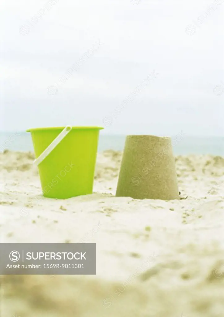 Bucket and molded sand on beach