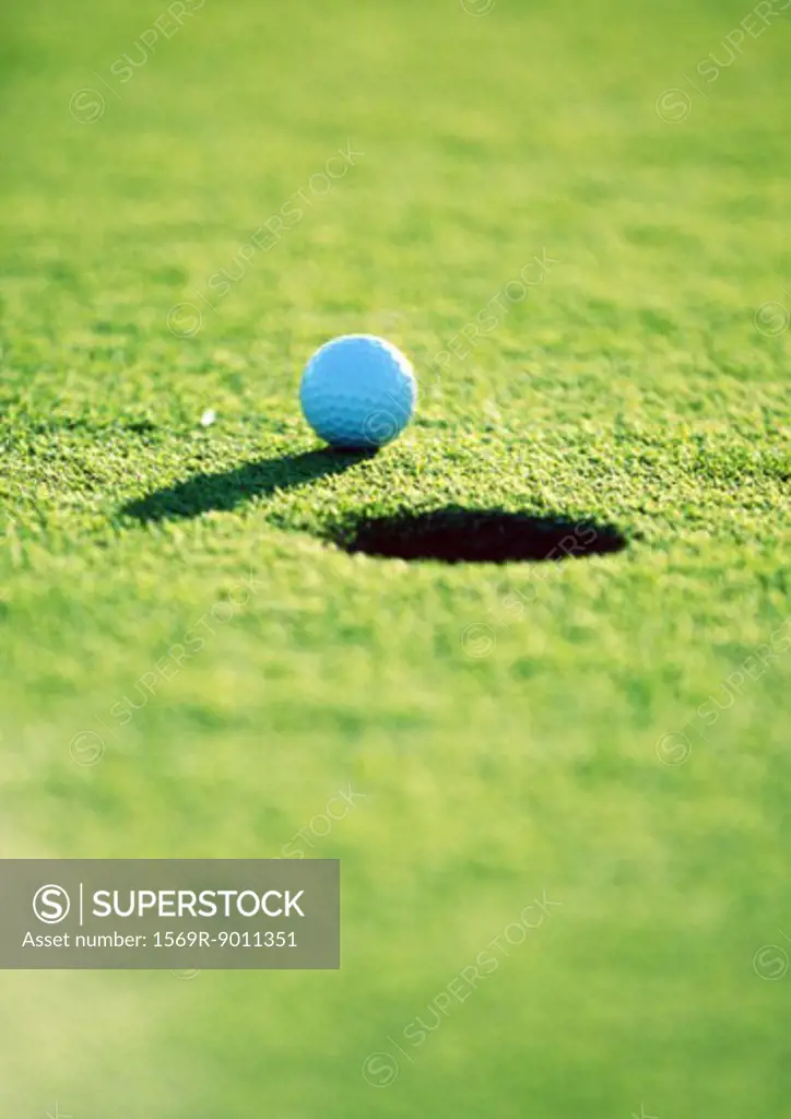 Golf ball near hole, close-up