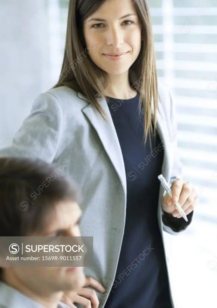 Businesswoman standing with pen in hand