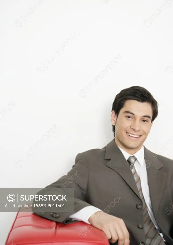 Businessman sitting on couch, smiling