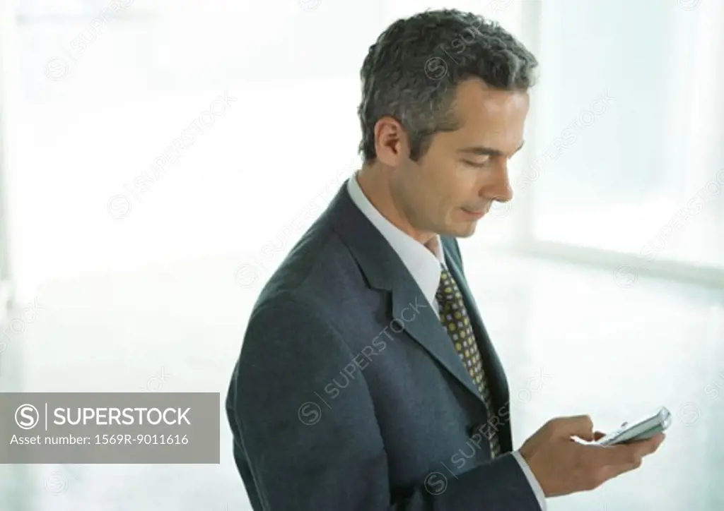 Businessman dialing cell phone