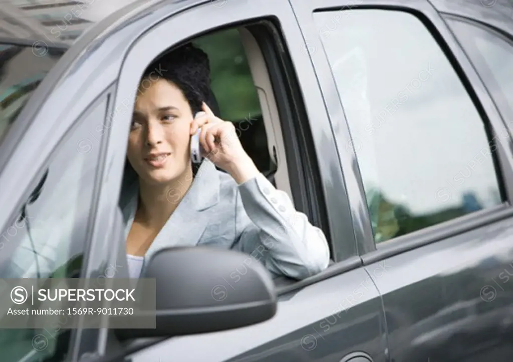 Businesswoman using cell phone in car