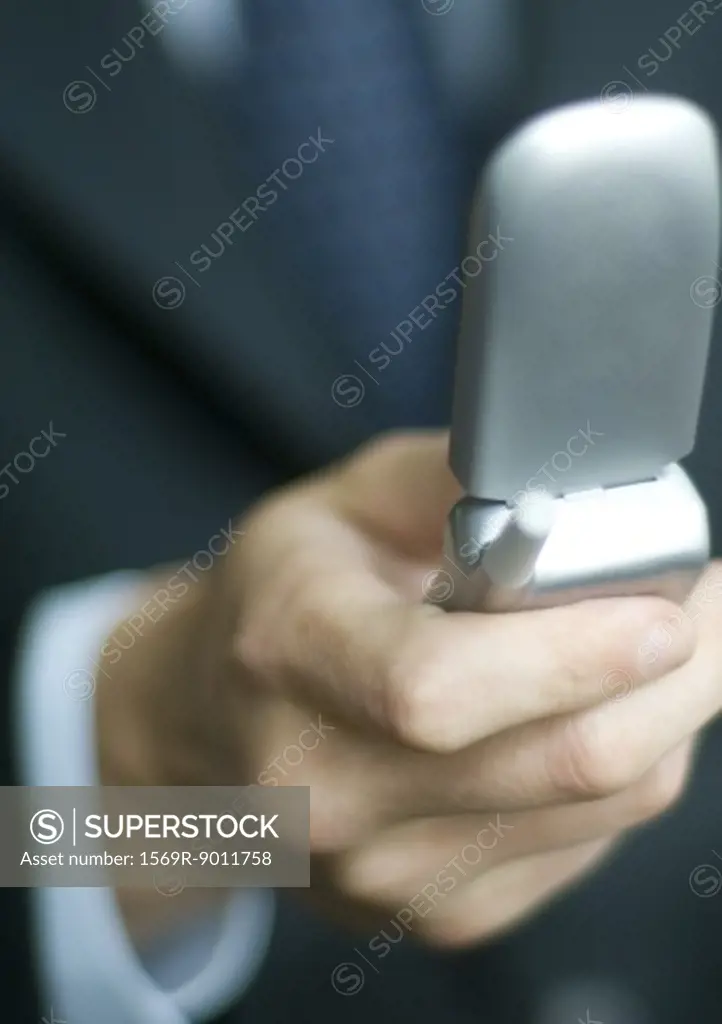 Businessman's hand holding flip phone