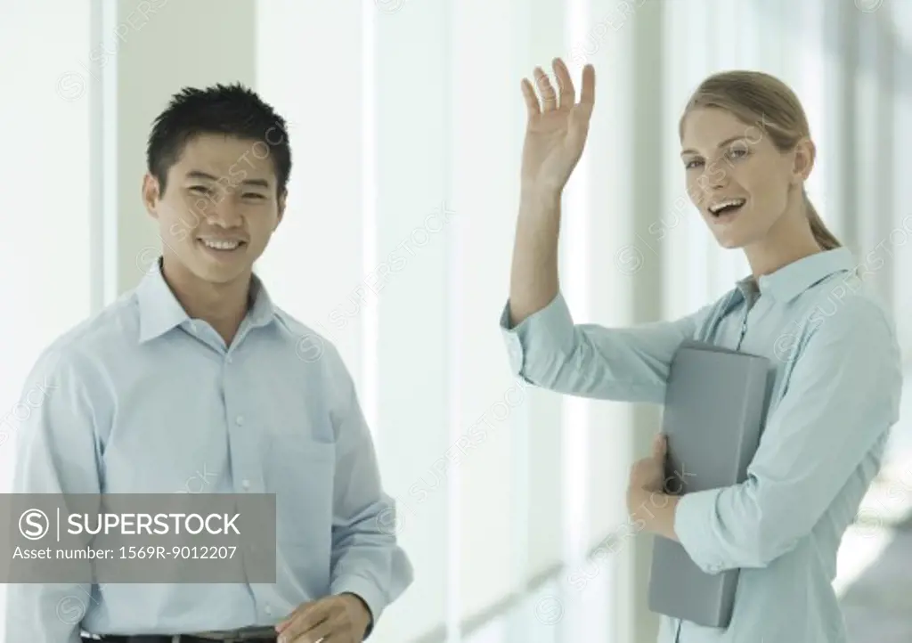 Office workers smiling and waving to camera