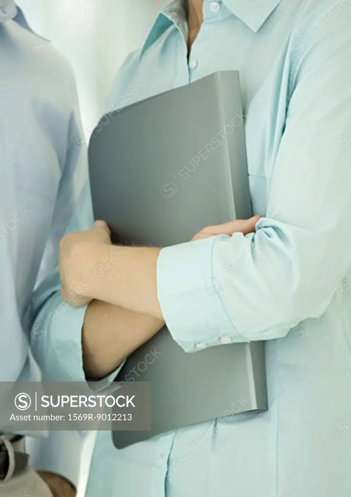 Office worker holding file against chest
