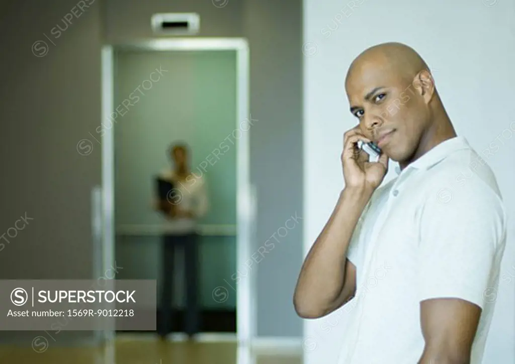 Man phoning, elevator in background