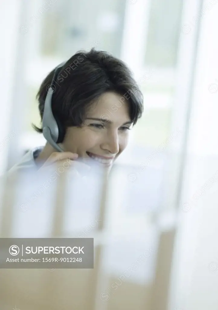 Woman wearing headset, reflection in foreground