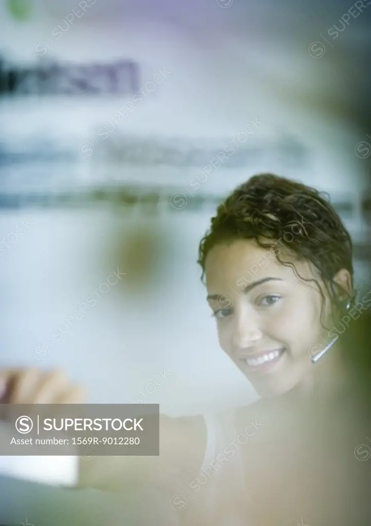 Woman wearing headset and holding out card