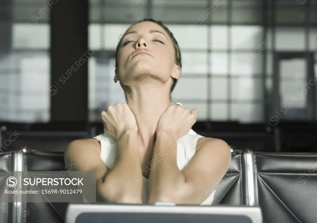 Female traveler stretching neck and closing eyes