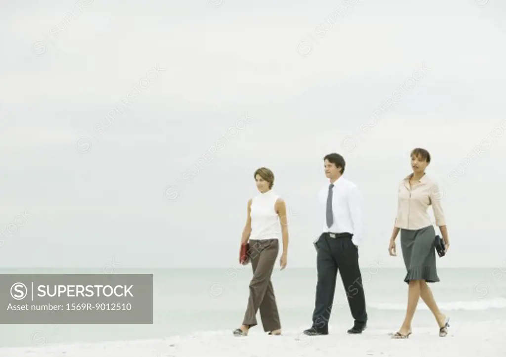 Business team walking on beach