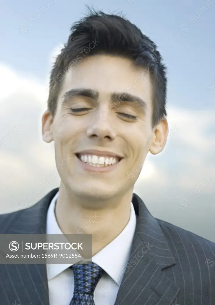 Young businessman, eyes closed, portrait