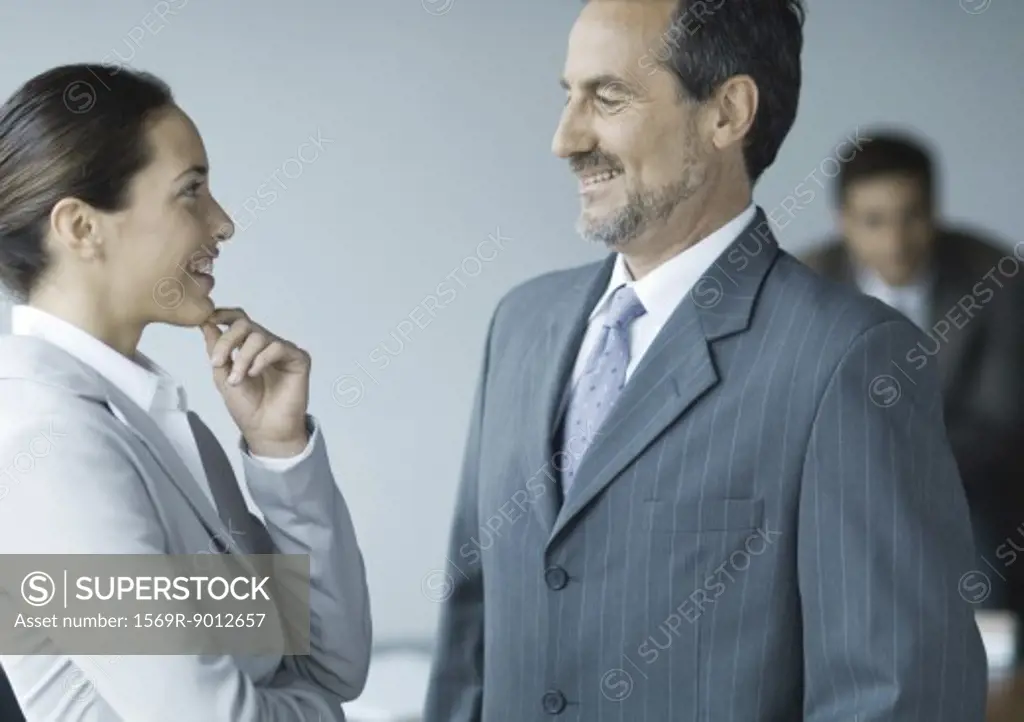 Business colleagues standing face to face, smiling