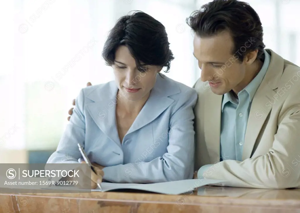 Couple signing document at counter