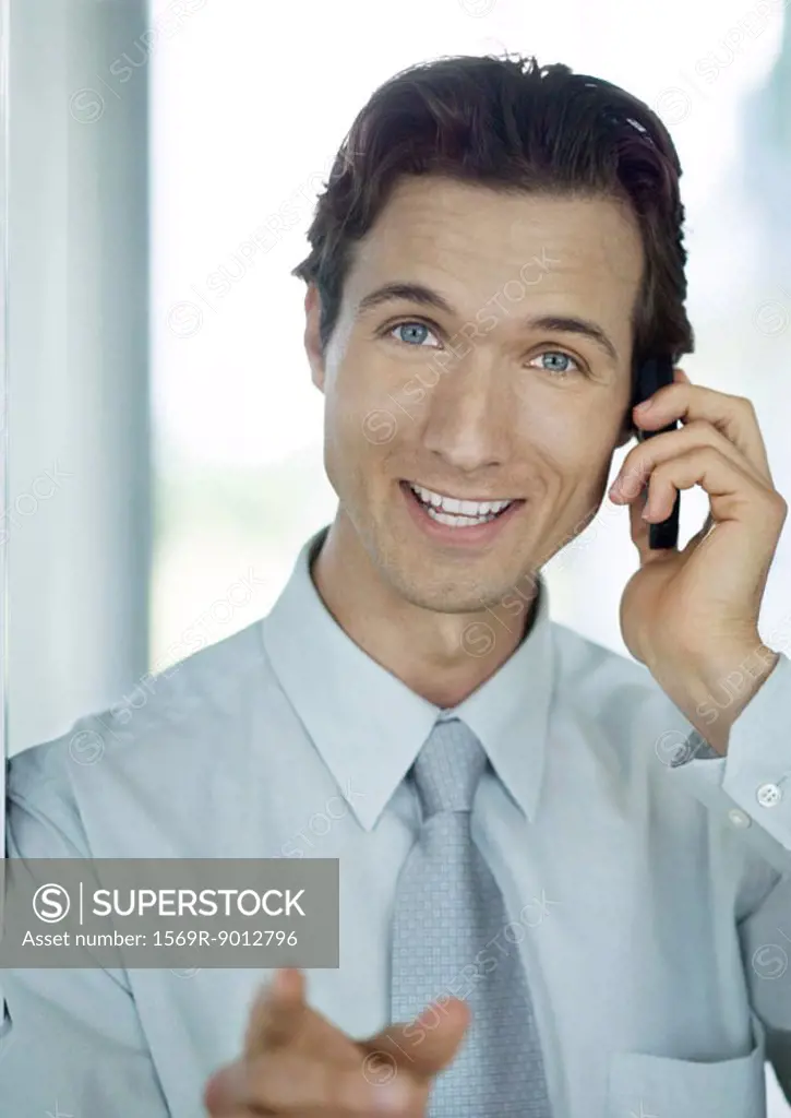 Businessman phoning and smiling