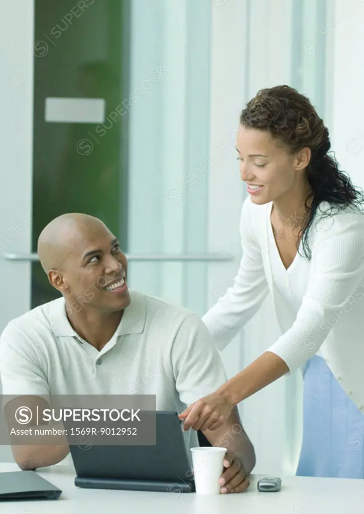 Woman helping male colleague