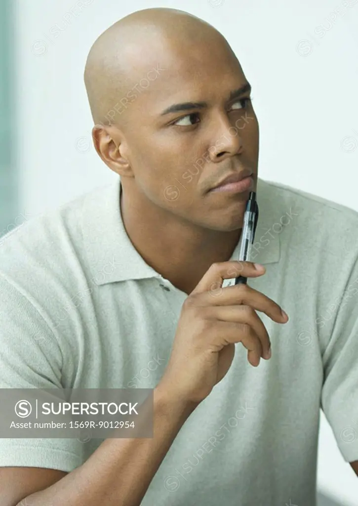 Man holding pen to chin, portrait