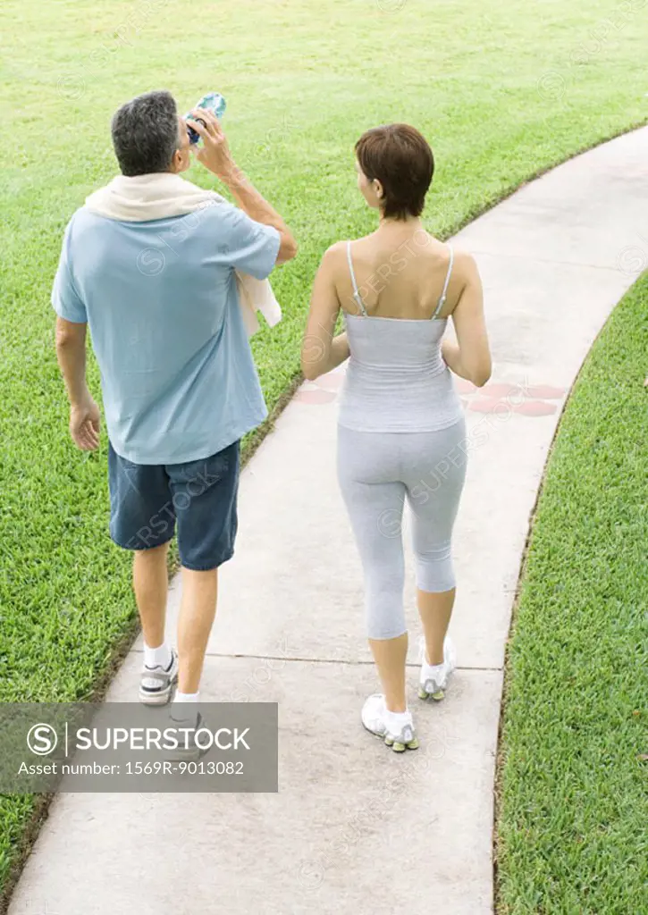 Mature couple walking on path after workout
