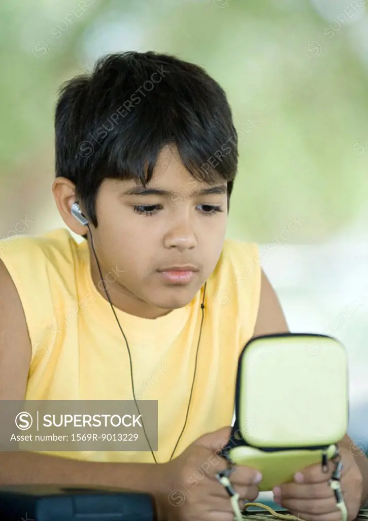 Preteen boy wearing earphones and holding case
