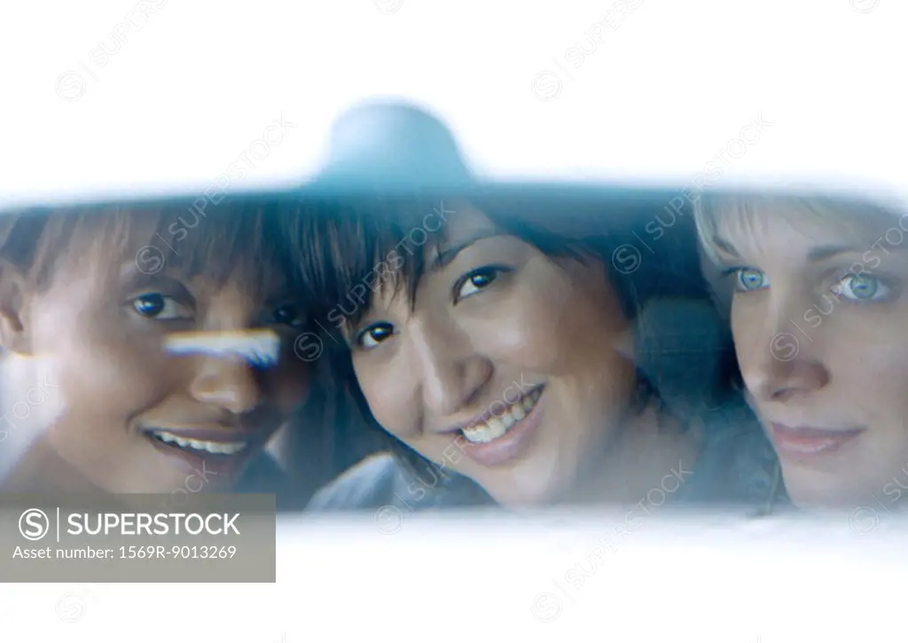 Young adult female friends seen in rear view mirror