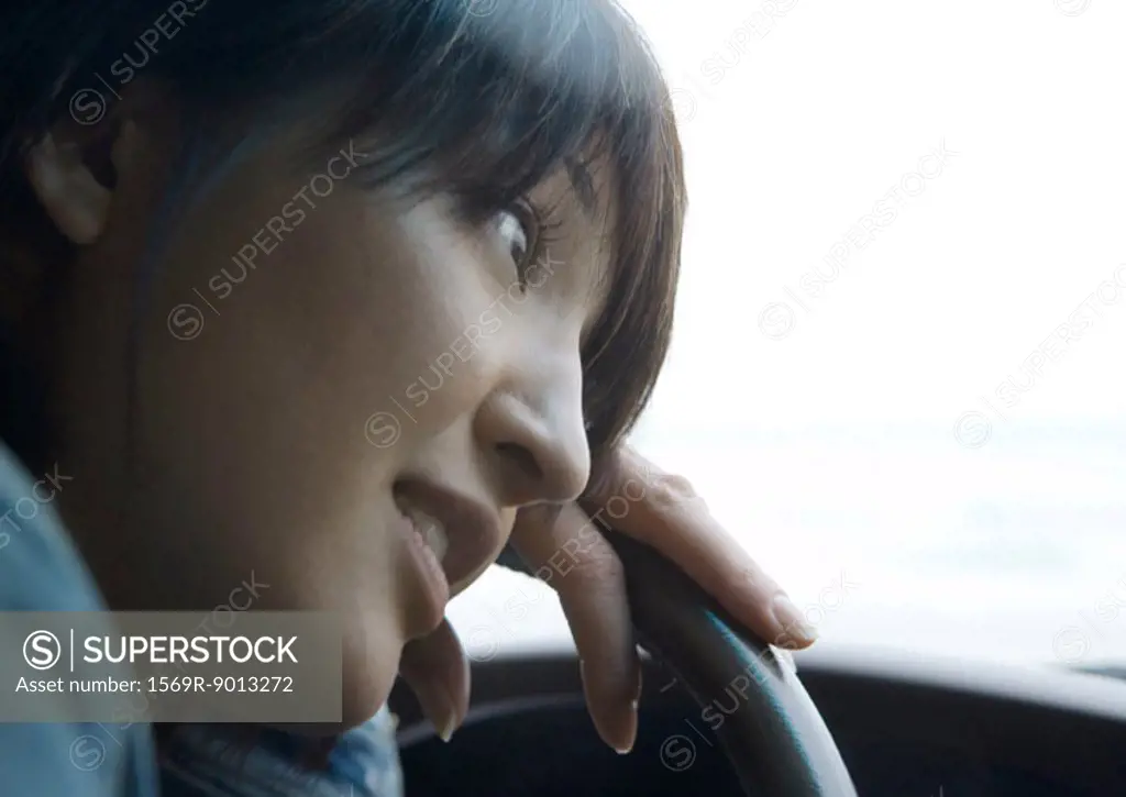 Woman leaning head against steering wheel
