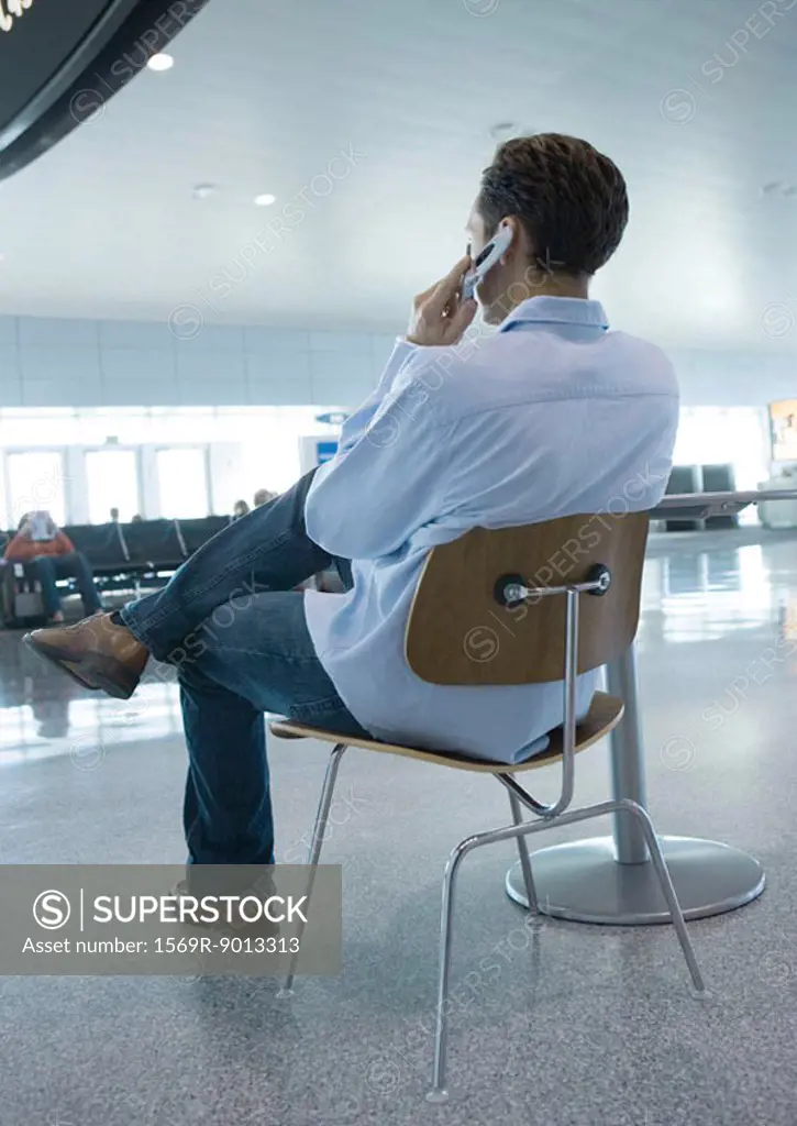 Man sitting in chair using cell phone
