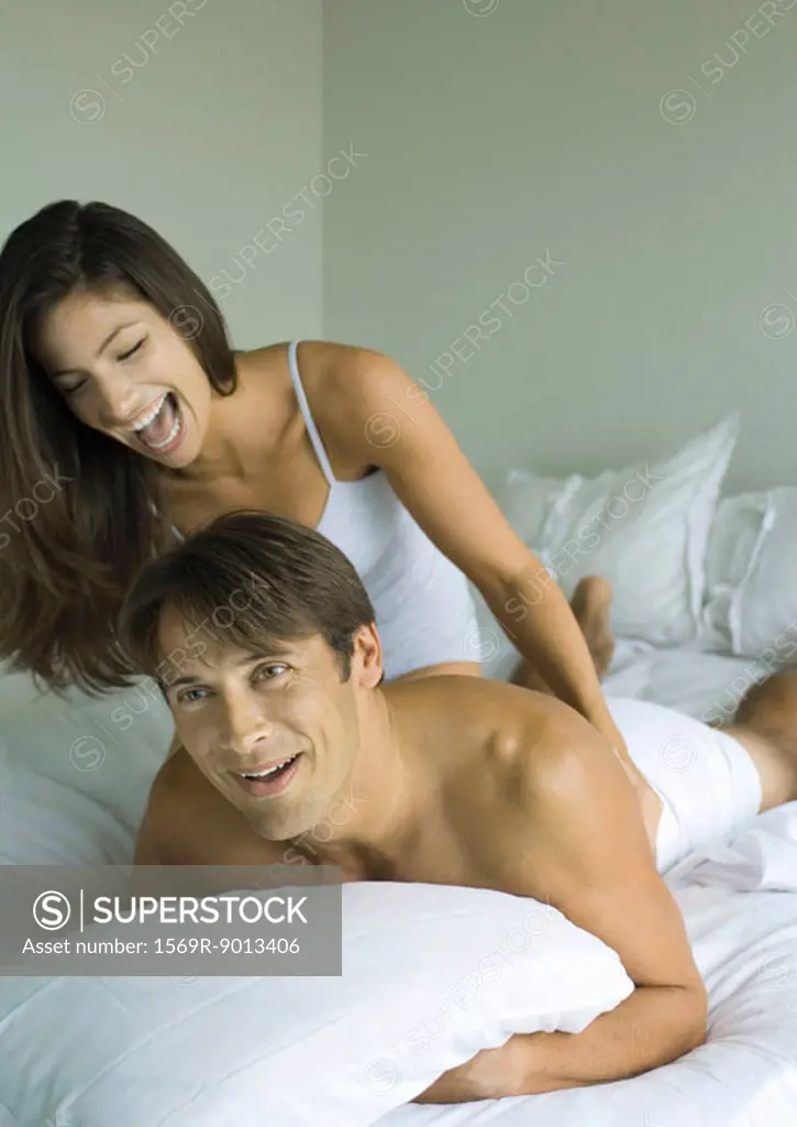 Woman tickling man in bed