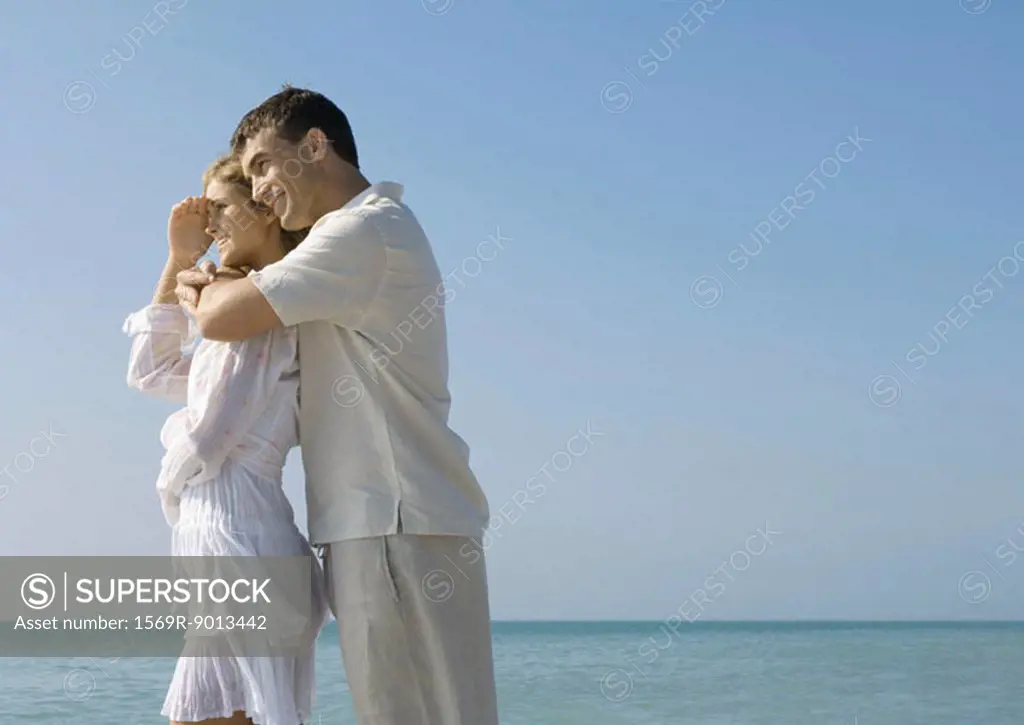 Man hugging woman on beach