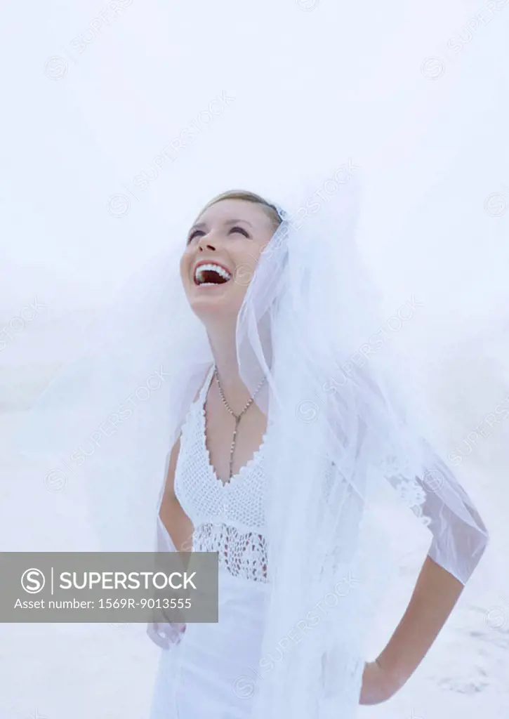 Bride laughing on beach